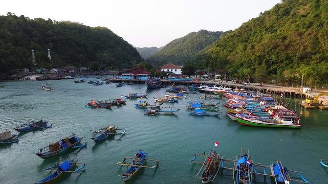 Aerial Drone View of Traditional Fishing Boats Moored at Sadeng Fishing Port During Sunset, Yogyakarta, Indonesia
