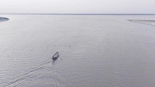 Professional 4K drone footage flying over a traditional wooden boat on the Padma River in Kushtia, Bangladesh. 