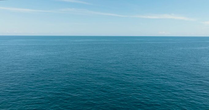 Aerial view of white clouds on blue sky over calm sea. Flight over the sea. Indonesia.