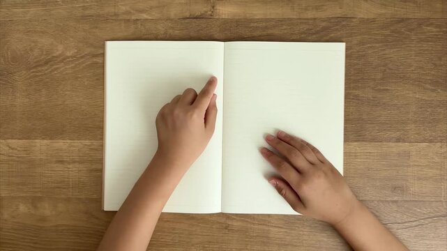 Child's Right Hand Holds Notebook While Left Hand Traces Ruled Lines with Finger, 4K