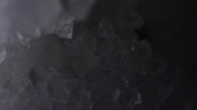 White crystal quartz inside of open geode. Transparent crystals in a cave. Zooming motion, dramatic changing lights. Gemstone