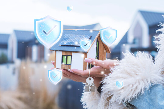Model house with solar panels and house keys in hand surrounded by digital shield icons. Home insurance, property protection, secure real estate, renewable energy and smart home security concept.