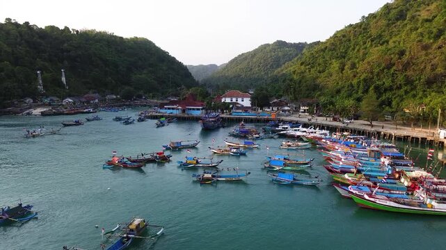 Aerial Drone View of Traditional Fishing Boats Moored at Sadeng Fishing Port During Sunset, Yogyakarta, Indonesia