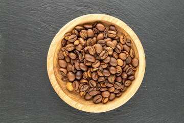 Fototapeta premium Roasted coffee beans on a slate stone. Top view.