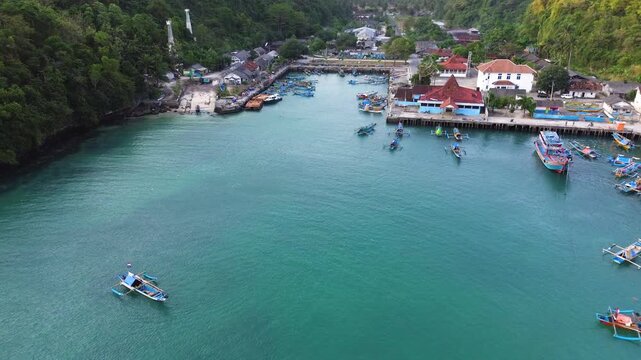 Aerial Drone View of Traditional Fishing Boats Moored at Sadeng Fishing Port During Sunset, Yogyakarta, Indonesia