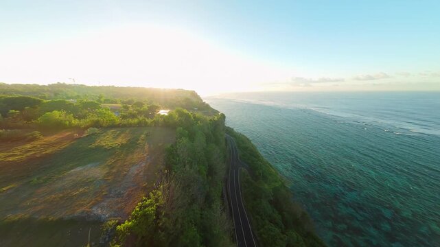 Smooth Cinematic Aerial Flight Along Coastal Cliffs And Scenic Road At Pantai Tanah Barak, Wide Angle Sunrise View Of Tropical Shoreline And Golden Horizon, Travel And Exploration