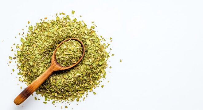 A high-angle view of loose dried yerba mate tea leaves on a white background with a rustic wooden spoon resting among the herbal mixture, background, culinary, beverage