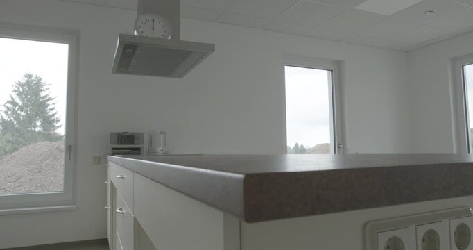 A white bathtub in a modern bathroom with grey tiles and grab bars