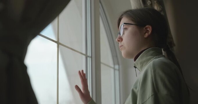 Thoughtful Girl Stand Near Window and Look Outside. 4K 10-bit