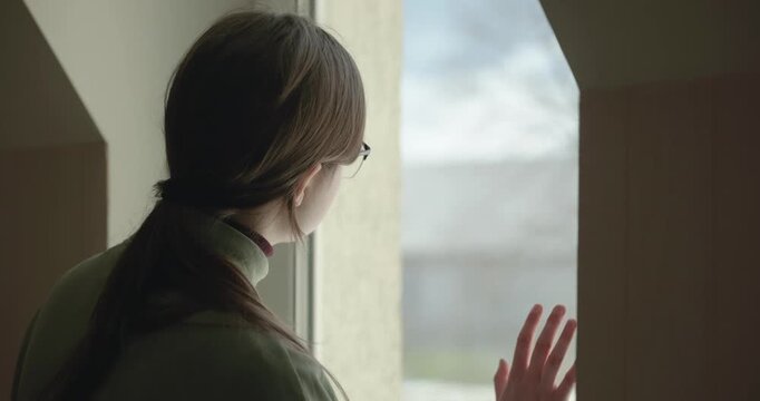 Thoughtful Girl Stand Near Window and Look Outside. 4K 10-bit