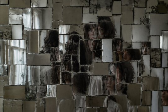 Fragmented mosaic of mirrored tiles on a wall with slightly misaligned reflections creating a pattern.