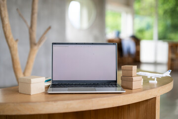 Fototapeta premium Modern Laptop on Wooden Table with Small Wooden Blocks in Cozy Bright Room