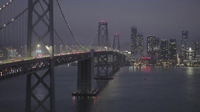 San Francisco Bay Bridge West Span Tower With View Of Sparkling City at Night
