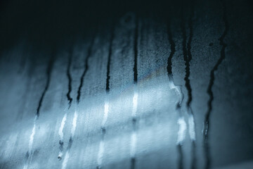 Naklejka premium Water droplet condensation moisture glass wet abstract blue texture closeup streak create moody abstract background with water droplet and condensation glass showing moisture and wet streaks blue