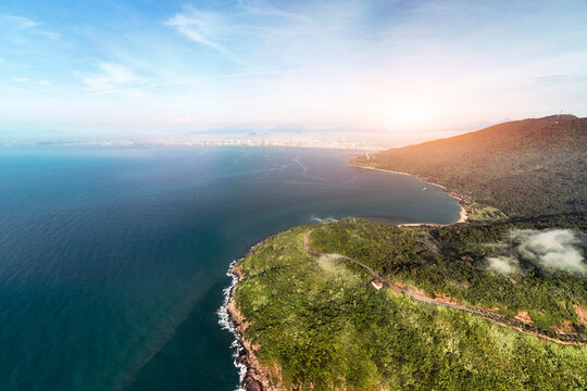 Aerial perspective shows Son Tra Peninsula jungle meeting the vast ocean in Da Nang, Vietnam