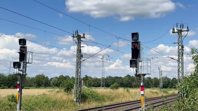 Bahnstrecke mit Signalanlagen und Oberleitung unter Sommerhimmel | Querformat - Ideal f&uuml;r Mobilit&auml;t, Verkehr und Infrastruktur.