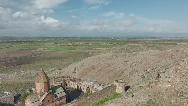 Aerial close view of Khor Virap monastery walls and church under a cloudy sky, Armenia