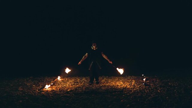 Fire performer with burning torches at night