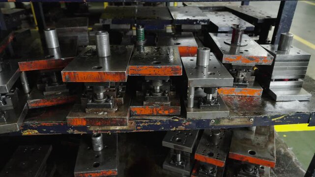 Metal Stamping Dies Stacked on Storage Rack in Factory Workshop