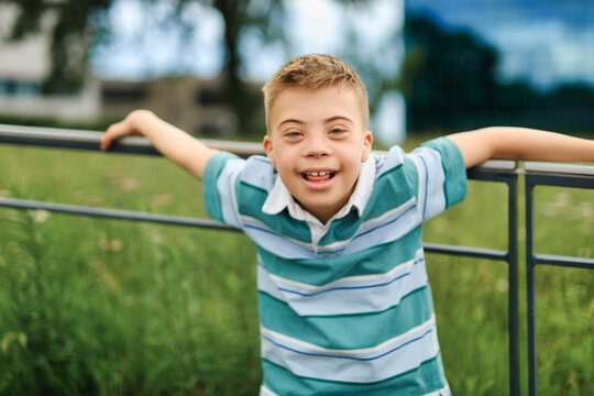 cute little child with trisomy 21 syndrome outside in summer season