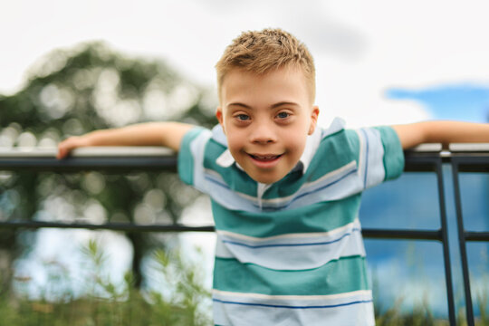 cute little child with trisomy 21 syndrome outside in summer season