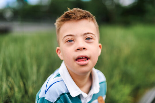 cute little child with trisomy 21 syndrome outside in summer season