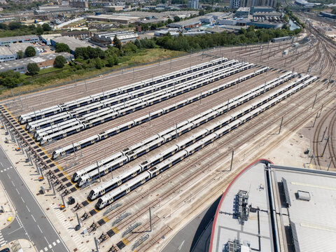 Aerial view of Old Oak Common Elizabeth Line Depot with multiple trains parked in parallel tracks, industrial infrastructure, and surrounding urban landscape in London, England, United Kingdom.