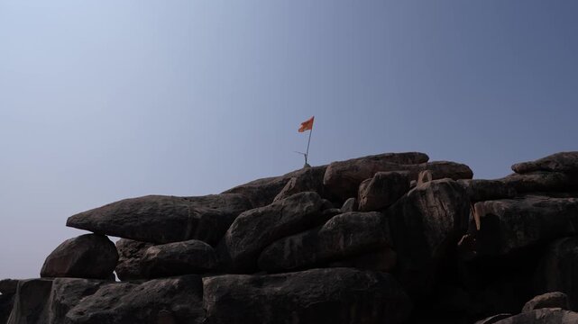 Saffron Flag on a Rocky Hill in Hampi, India