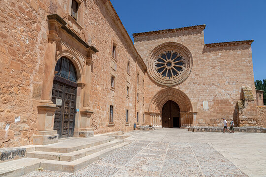 Santa Maria de Huerta, Spain. Western facade of the Cistercian monastery church with Gothic portal, archivolts, large Romanesque rose window and the guesthouse entrance