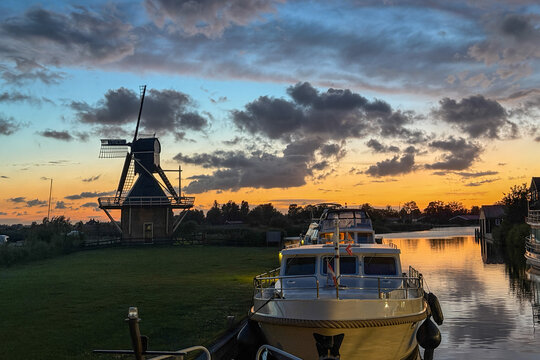 Boot und Windm&uuml;hle am Kanal im Abendlicht, Joure, Friesland, Niederlande