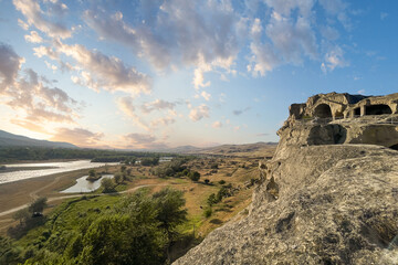 Georgian landscape with Kura river sunset sky with cloud and famous Uplistsikhe cave town in Georgia © millaf (Nemchinova)