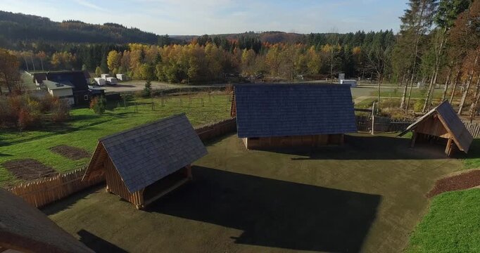Aerial top down view of a reconstructed historic wooden fort village with traditional thatched houses