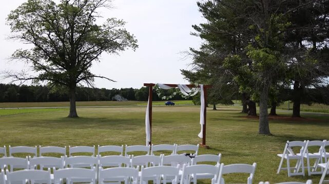 Outdoor wedding chairs and arch on a grassy lawn