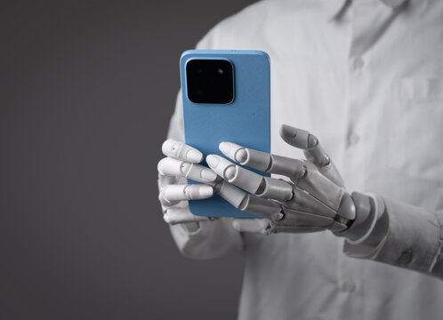 Robot hands using a blue smartphone device on dark gray background.