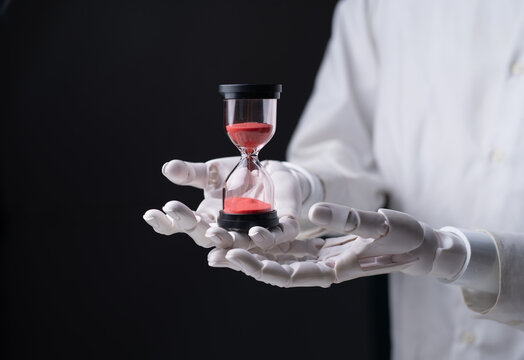 Robot hands holding a red hourglass on dark black background.