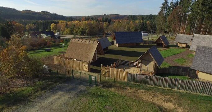 Aerial top down view of a reconstructed historic wooden fort village with traditional thatched houses
