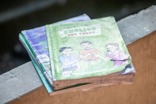 Stack of old comic books on a wooden surface outdoors
