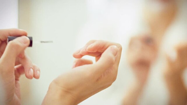 Close-up of a girl gently brushing cuticle oil along her nail line with an applicator brush, the soothing beauty ritual softens and nourishes cuticles at home, promoting healthy nails