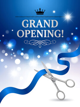 Silver scissors cut a blue ribbon for a grand opening event with bright glowing lights