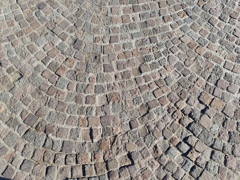 Ostia, Rome, Italy - June 20, 2026, detail of the cobblestone pavement, traditional blocks of volcanic stone (leucitite) used to pave historic streets and squares, on the Ostia Lido pier.