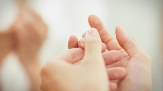 In a personal grooming setting, a girl gently massages her cuticles with a softening agent as part of her daily nail care routine, promoting hand beauty and health through nourishment and hydration