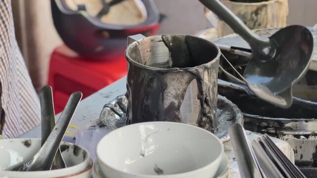 Authentic slow motion close-up of a street food vendor ladling black bean sweet soup at a rustic stall