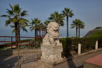 Fototapeta premium Intricately carved dragon sculpture is a striking feature of the Parque Chino (Chinese Park) in Miraflores, serving as a powerful symbol of strength and good fortune. Perched along the cliffs of the M