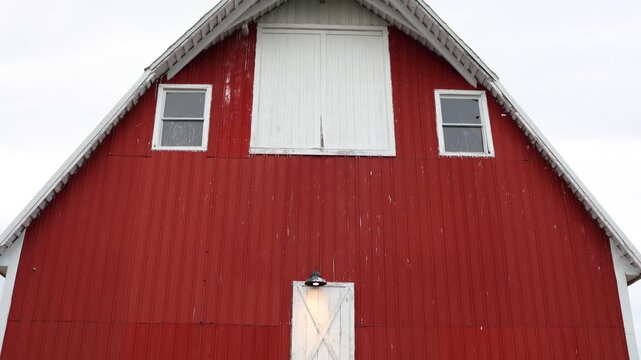 Red barn front with white trim and loft doors