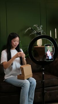Young female blogger recording a video for her channel showing how to apply cosmetics