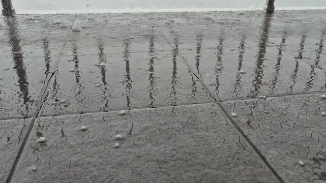 Hailstones falling onto the porch surface, close-up