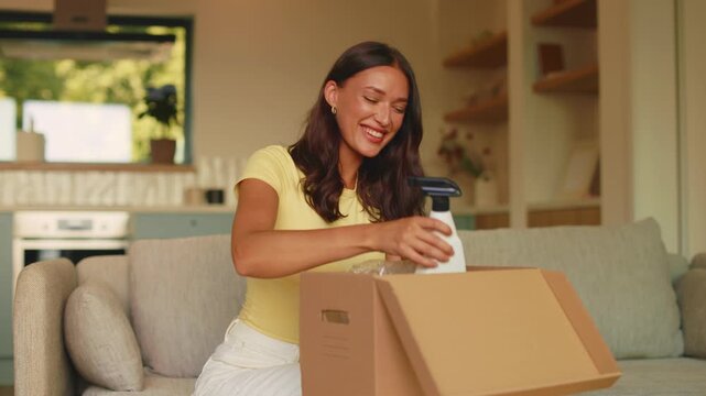 Smiling woman checking cleaning supplies from online delivery box at home, 4K