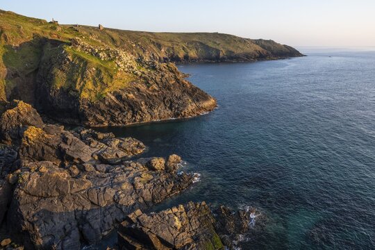 Coastal landscape at Botallack Mine, also known as Crown Mine. The ruins of Wheal Edward in the background. Evening, golden hour. Botallack, Penzance, Cornwall, England, Great Britain