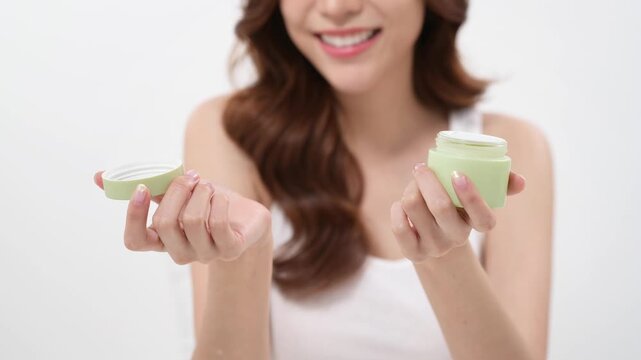 Skincare Routine Showcasing a Woman With a Jar of Cream in a Bright Setting