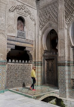 Tourist in the courtyard, Madrasa Bou Inania, madrasas, Arabic ornamentation, Fes, Morocco
